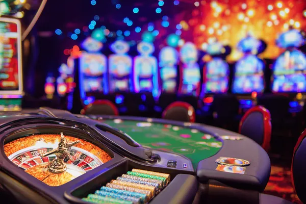 A man celebrating a winning moment on his laptop while gaming symbols float around him, capturing the excitement of STARMAX88 games.